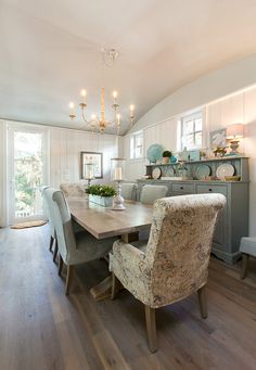 a dining room table with two chairs and a chandelier