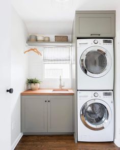 a washer and dryer in a small room with wood flooring on the side