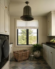 a washer and dryer sitting in a kitchen next to a window with the light on