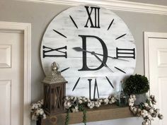 a large clock mounted to the side of a wall next to a potted plant