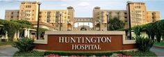 the sign for huntington hospital in front of an apartment building with trees and bushes