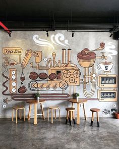 a mural on the wall of a coffee shop with wooden tables and stools in front of it