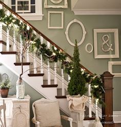 christmas decorations on the banisters and stairs in a house with white trimming