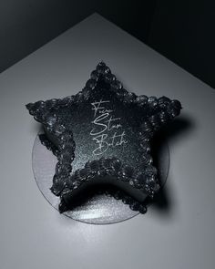 a black and white photo of a star shaped cake on a plate with writing on it