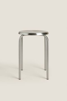 a small metal table sitting on top of a white floor