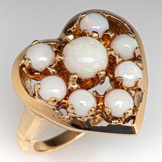 This lovely heart shaped ring features 8 round cut opal cabochons and is crafted of 14k yellow gold. This ring is currently a size 5.5 and shows a patina. Opal Heart Ring, Heart Shaped Ring, Heart Shaped Rings, Modern Jewelry, Estate Jewelry, Antique Jewelry, Round Cut, Heart Ring, Heart Shapes