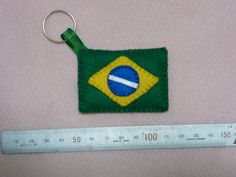 a green and yellow keychain with a flag on it