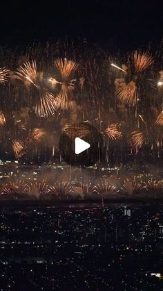 fireworks are lit up in the night sky above a cityscape with buildings and lights