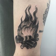 a black and white fire tattoo on the arm