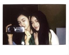 two young women taking a photo with a camera