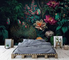 a bed sitting in front of a wall with flowers and plants painted on the walls