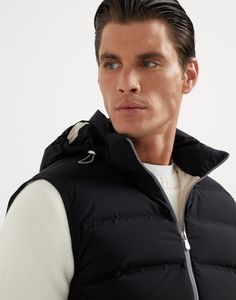 Bonded taffeta down vest with heat-bonded seams and detachable hood The quality of the materials and skillful techniques enhance the sporty feel of this down vest with detachable hood. The typical texture of taffeta, smooth and matte-looking, highlights the season’s nuances and enriches this quilted outerwear piece with heat-sealed profiles reminiscent of technical activewear, for a contemporary style. The inner membrane and light padding ensure comfort and protection. Down Vest With Padded Collar, Sleeveless Down Vest With Padded Collar, Sleeveless Black Down Outerwear, Fitted Nylon Vest For Cold Weather, Black Functional Vest With Padded Collar, Functional Black Vest With Padded Collar, Fitted Nylon Vest Outerwear, Functional Black Down Vest, Functional Nylon Vest With Detachable Hood