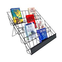 a metal book rack holding several books on it's sides, with the bottom section open