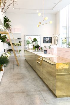 the interior of a flower shop with gold counter tops