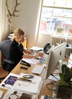 a woman sitting at a desk in front of a computer