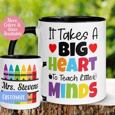 two coffee mugs sitting on top of a tree stump with the words it takes a big heart to teach little minds