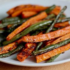 cooked carrots and green beans on a white plate