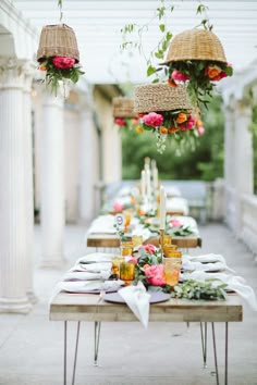 an outdoor dining area with flowers hanging from the ceiling