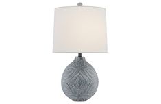 a table lamp with a white shade on it's base and an intricate design