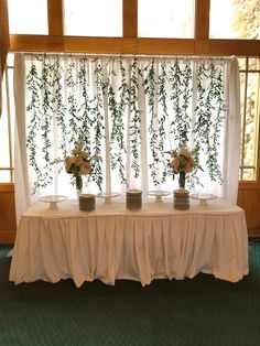 three vases filled with flowers sitting on top of a table next to a window