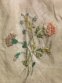 an embroidered piece of cloth with flowers on it