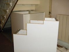 an unfinished kitchen under construction with cabinets and stairs in the foreground, next to a stair case