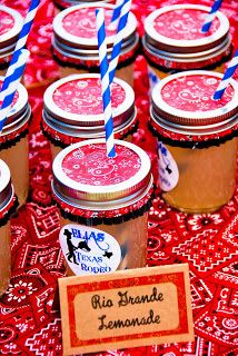 there are many jars with straws in them on the tablecloth and one has a sign that says, ella brande lemonade