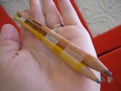 a person holding a yellow pencil in their hand with the number six on it's side