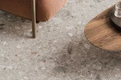 a coffee table with a glass on it next to a brown chair and side table