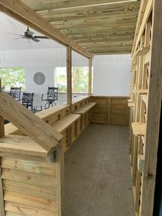 the inside of a building with wooden benches and tables on each side of the room