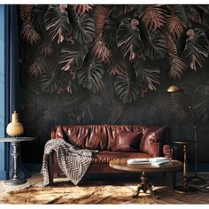 a brown leather couch sitting in front of a wall covered with plants and foliages