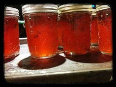 four jars filled with liquid sitting on top of a counter next to another jar full of liquid