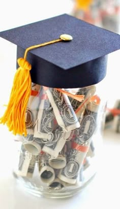 a graduation cap sitting on top of money in a jar