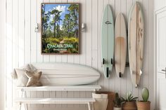 three surfboards are hanging on the wall next to a bench and potted plant