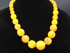 "DESCRIPTION: This vintage necklace, hailing from the 1960s, is a captivating display of mid-century fashion with its graduating array of eggyolk-colored resin beads. In excellent condition, it exudes a warm and nostalgic charm, measuring a substantial 23\" in length. The beads range from a dainty 12mm to an eye-catching 26mm, making this necklace a versatile and stylish accessory that adds a pop of vintage flair to any ensemble. NOTE: Insurance fee and handling fee are included in the shipping fee for items worth $400 and above. SHIPPING: The shipping fee includes postage, packaging, and handling. We typically ship items within one day of receiving payment. If you're buying multiple items, we offer combined shipping, but please wait for your invoice before checking out. For international Vintage Orange Beaded Necklaces For Formal Occasions, Yellow Costume Jewelry Necklace For Formal Occasions, Yellow Costume Jewelry Necklace For Formal Events, Polished Vintage Beads, Retro Necklaces With Large Round Beads, Vintage Polished Yellow Beads Jewelry, Vintage Yellow Single Strand Jewelry, Vintage Yellow Jewelry With Polished Beads, Vintage Orange Round Bead Necklace