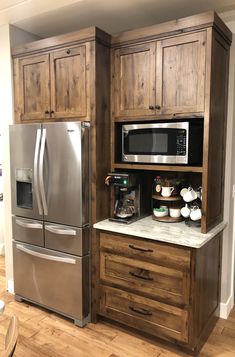 a stainless steel refrigerator freezer sitting inside of a kitchen next to a wooden cabinet