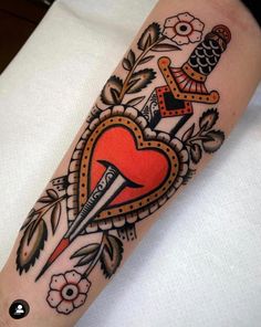 a tattoo with an orange heart and two swords on the side of his arm,