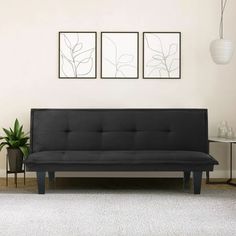 a black futon sofa sitting on top of a white rug