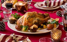 a large turkey on a white plate with red table cloth