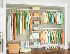 an organized closet with clothes, shoes and boxes on the floor in front of it