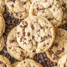 chocolate chip cookies are piled on top of each other in the middle of a pile