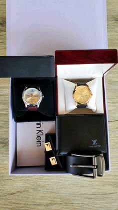 two watches and a wallet in a box on a wooden table next to each other