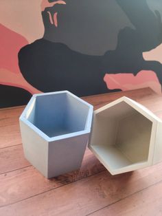 two white vases sitting on top of a wooden floor