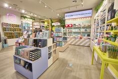 the inside of a store with lots of books on shelves and desks in it