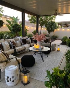 an outdoor living area with couches, tables and candles