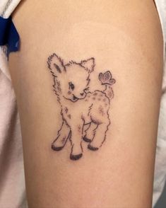 a small tattoo on the arm of a woman's left thigh shows a little lamb