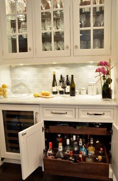 an open refrigerator in a kitchen filled with bottles