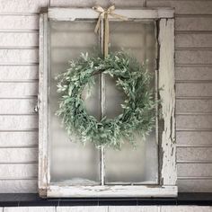 an old window with a wreath hanging on it