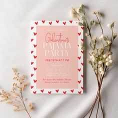 a pink and red valentine's party card with hearts on it next to some flowers