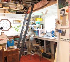 a room with a ladder that is attached to the ceiling and desk in front of it